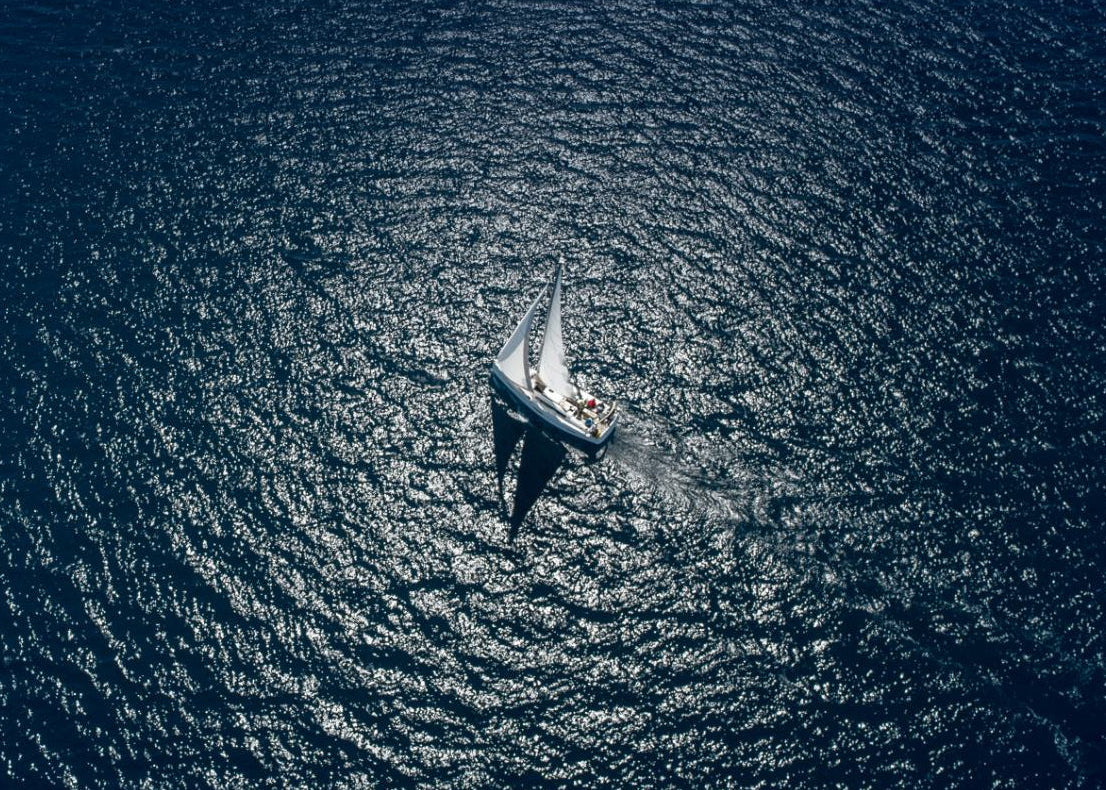 Aerial view of a sailboat on a calm blue sea